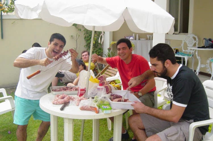Friends sharing beers and good times around a Brazilian BBQ
