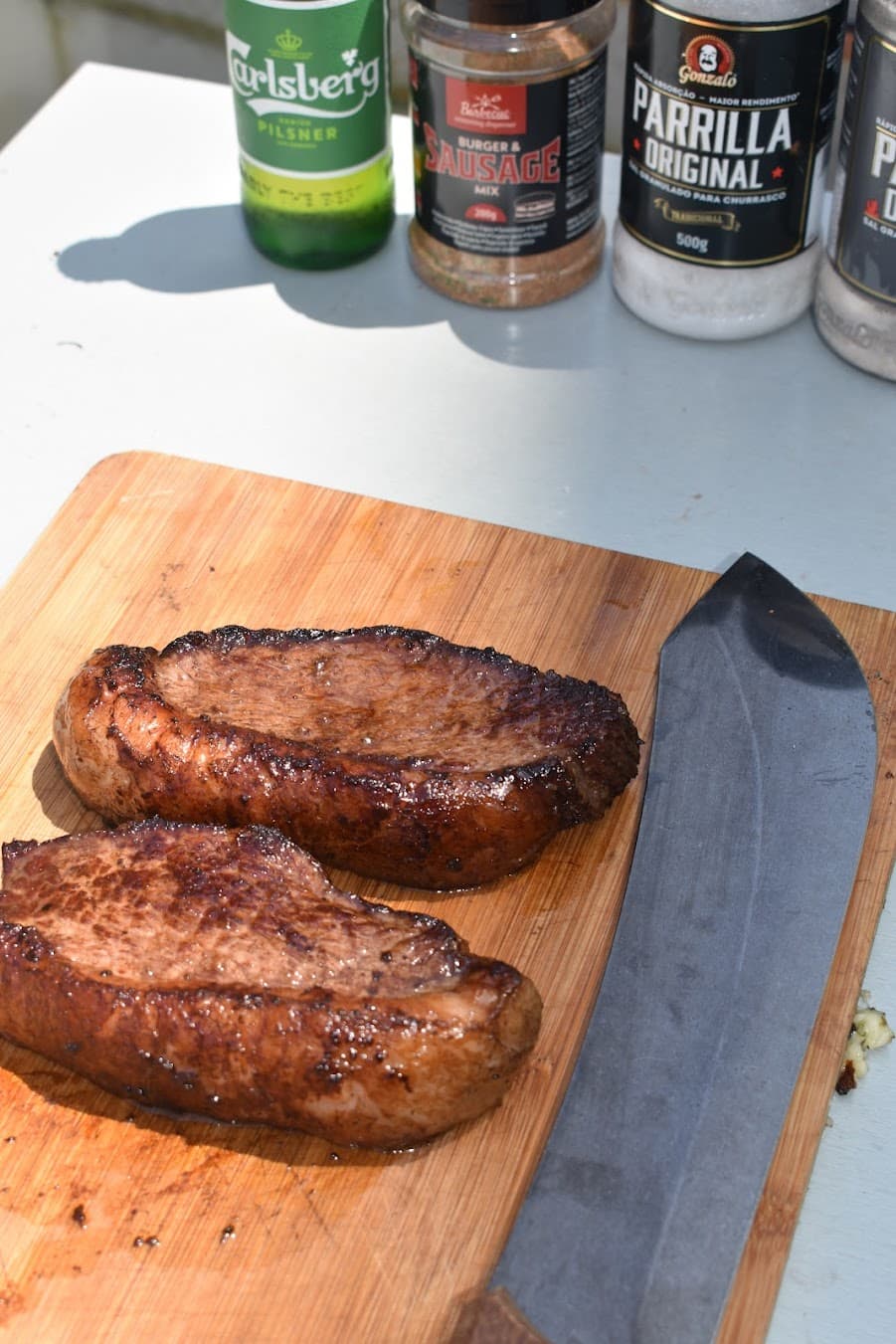 Grilled linguiça on board with Parrilla salt and knife