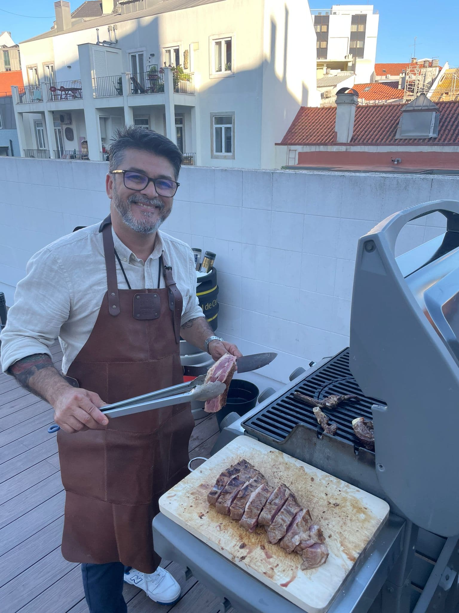 Marcelo on the Cascais rooftop — smiling with picanha and tongs
